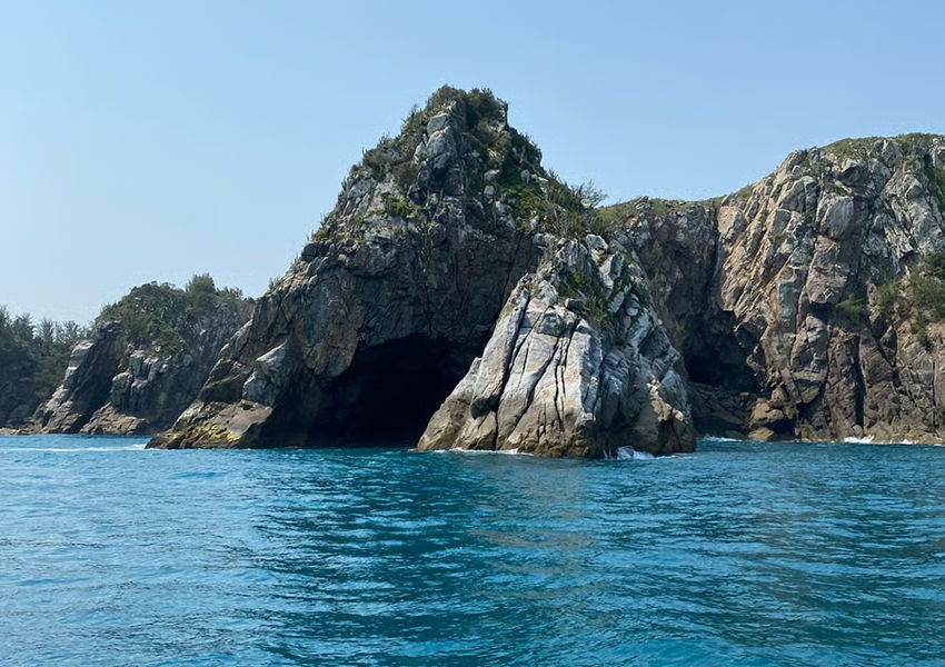 Entrada da Gruta Azul em Arraial do Cabo, com formação rochosa imponente, visitada durante o passeio de barco.